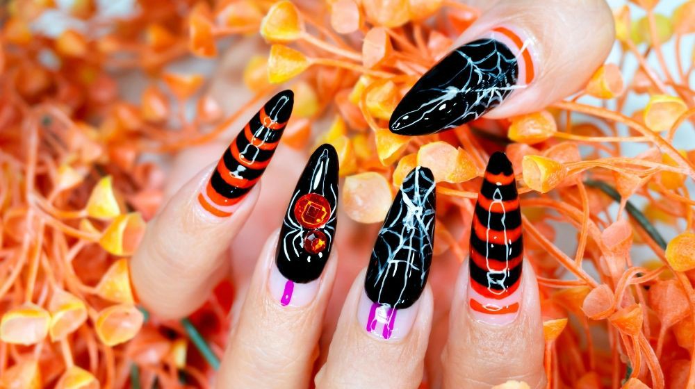 Beautiful woman Fingernail with Black and Orange color Gel Nail Art Design for Halloween Festival Painting Cobweb and shiny Crystal Spider on Ringfinger | Top DIY Halloween Nail Art Ideas | Featured | Halloween gel nails