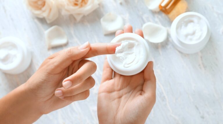 young woman applying body cream | Skin Care Products That Will Save Your Dry Skin In Winter | dry skin in winter | Featured