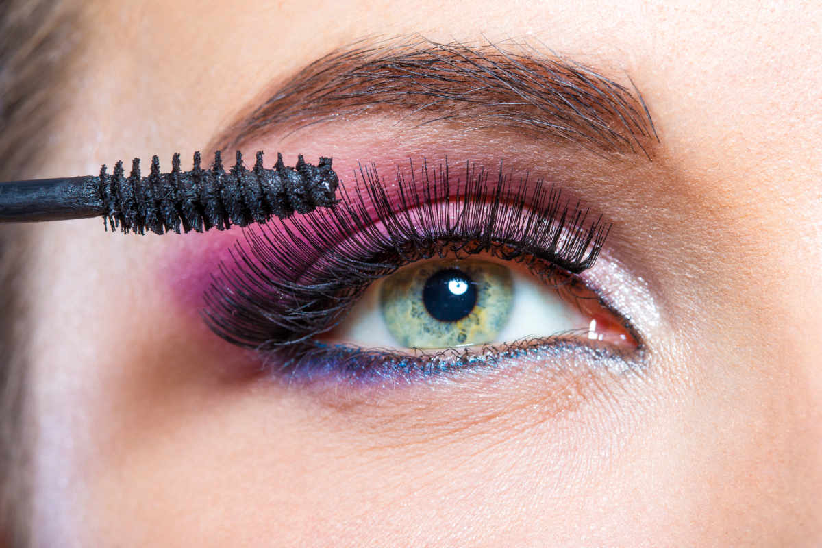 Female eye with bright make-up and brush applying mascara on eyelashes | Gorgeous Holiday Makeup Looks | holiday makeup tutorial