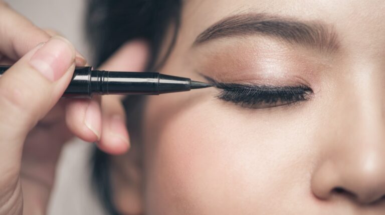 Portrait of beautiful girl touching black eyeliner to her eyelid | Great Eyeliner Tips For Makeup Junkies | Featured