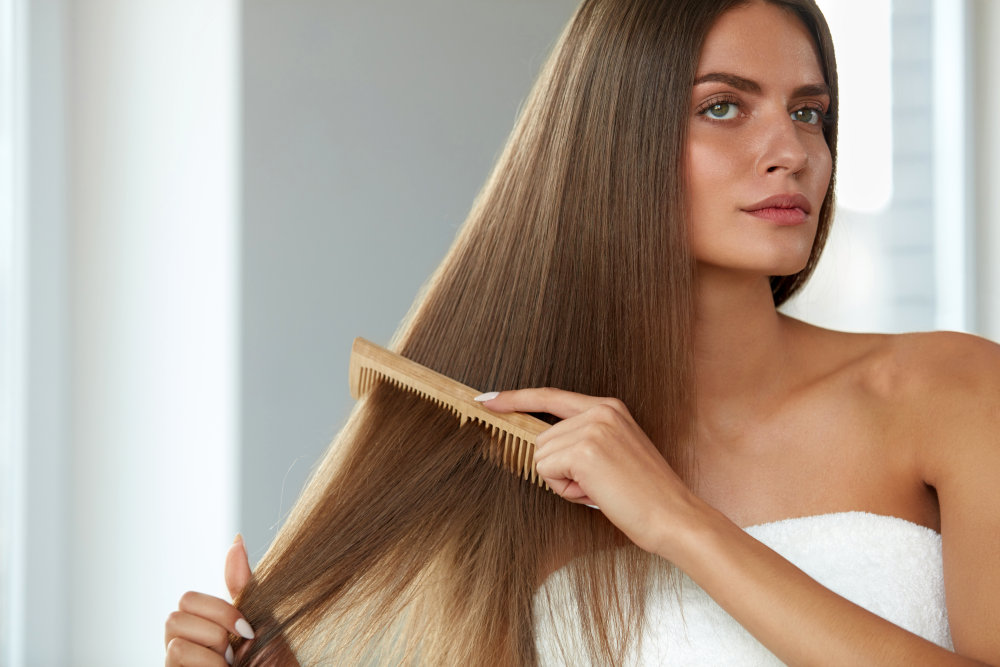 Portrait Of Sexy Young Woman Brushing Straight Natural Hair With Comb | How to Prevent Breakage | Hair Breakage FAQs | best way to wear hair to bed to prevent breakage