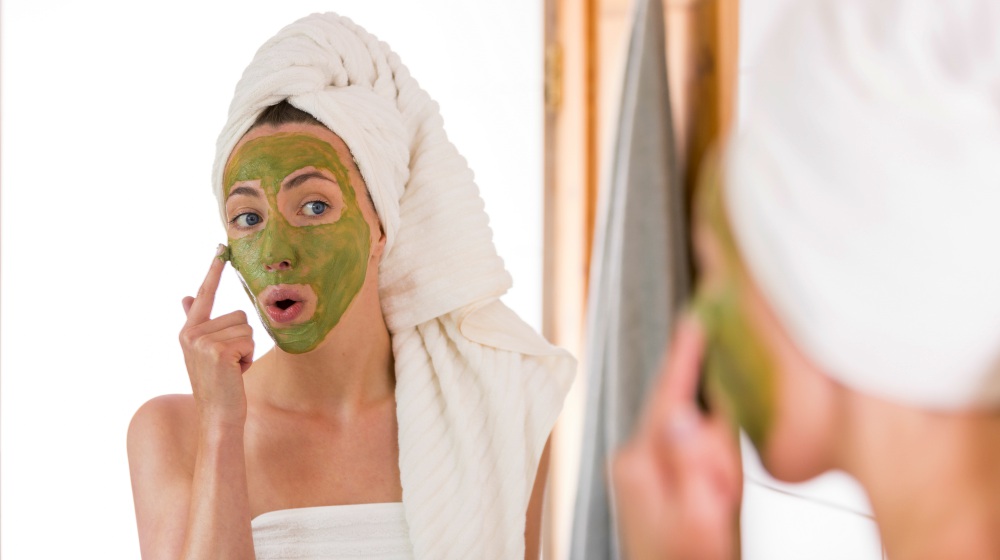 woman applying green organic face mask | Secrets To Get Glowing Glass Skin | glass skin