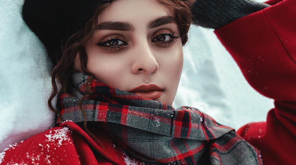 woman in red and black coat | winter beauty products | featured
