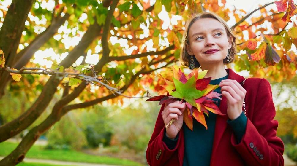 MAC-y1fC1cE-young-woman-with-bunch-of-colorful-autumn-leaves | Beautiful Reasons To Love Fall | Makeup, Fashion, And More | Featured