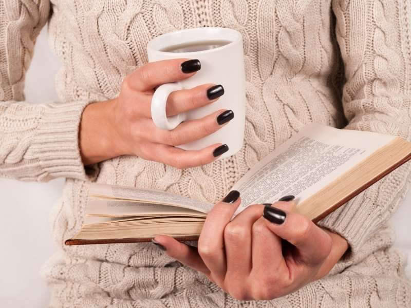MADaAtKqv2c-female-holding-tea-cup-and-reading-book-in-sweater | fall nail colors