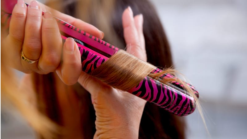 curling a hair with a pink curling iron | Hairstyle Guide: Curling Hair With Flat Iron In Simple Steps | flat iron