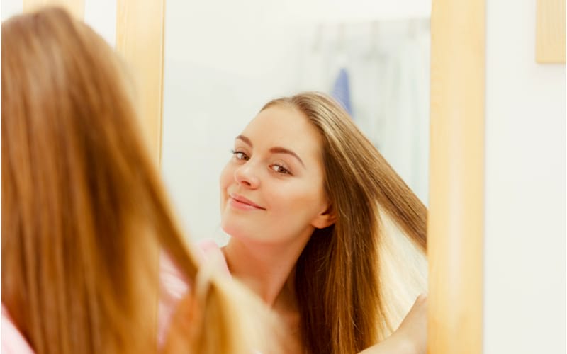 Woman brushing her hair | how to dutch braid 