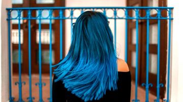 blue haired woman facing metal fence | Upgrade Your Hairstyle With These 23 Shadow Root Hair Color Ideas | shadow roots | Featured