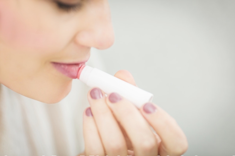 woman putting lipstick | best lip gloss drugstore