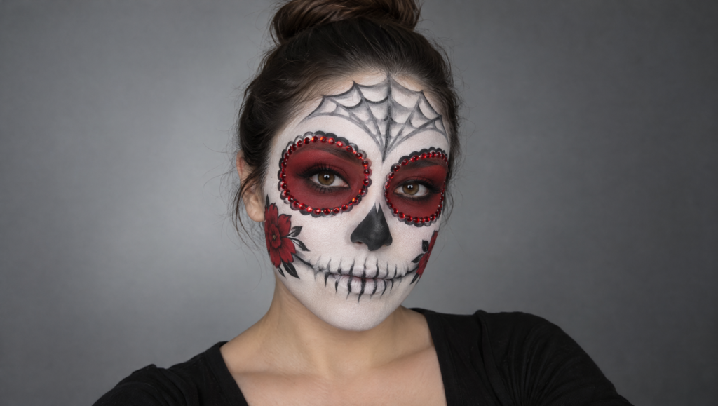 Day of the Dead makeup tutorial step 12: finished white, red and black skull makeup with crystals and cheek flowers