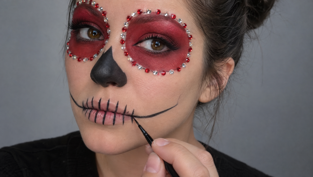 Day of the Dead makeup tutorial step 10: fine black brush painting vertical teeth lines across the lips and curved jaw lines